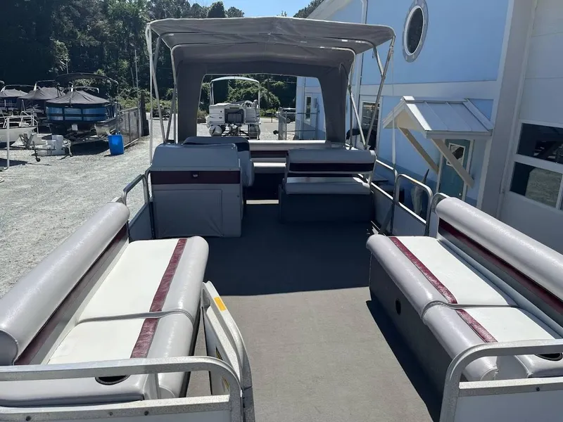 Slide: The Image of 1991 GODFREY MARINE 24 Executive pontoon boat with canopy and seating, docked outdoors. - 4