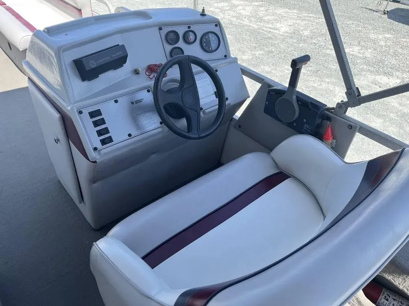 Slide: The Image of 1991 Godfrey Marine 24 Executive boat dashboard with steering wheel and controls. - 7