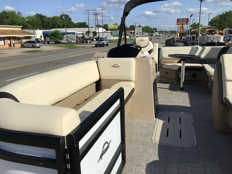 Slide: The Image of 2025 G3 Select 322RF pontoon boat with beige seating, parked near a road. - 20