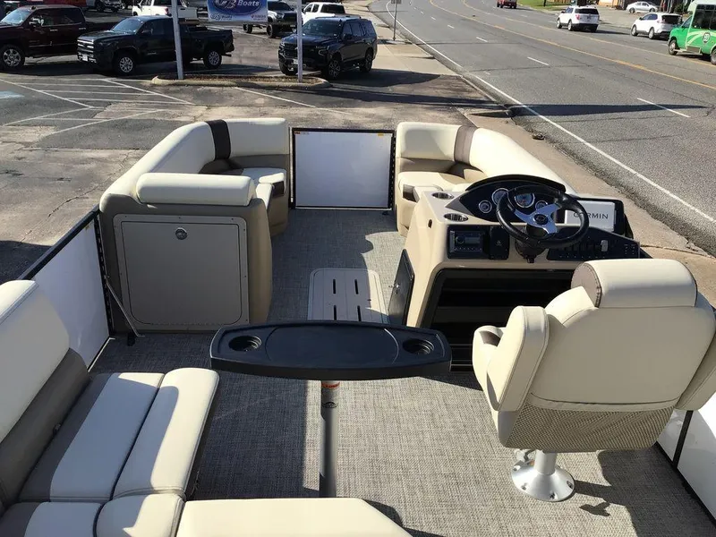 Slide: The Image of 2025 G3 Select 322RF pontoon boat interior with beige seating and steering console. - 31