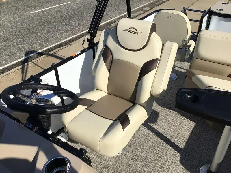 Slide: The Image of 2025 G3 Select 322RF boat interior with beige and brown seating, steering wheel, and cup holders. - 36