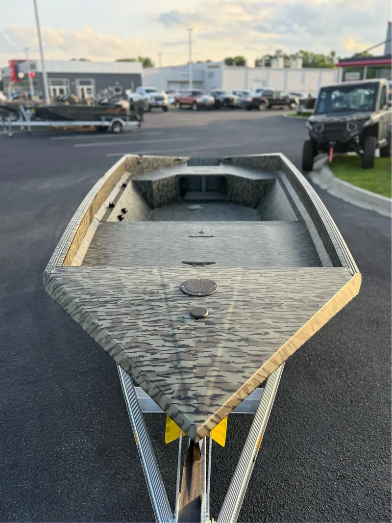 Slide: The Image of 2025 EDGE BOATS 656 DB SPORTSMAN with camouflage design on a trailer in a parking lot. - 7