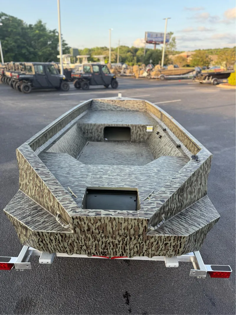 Slide: The Image of 2025 EDGE BOATS 656 DB SPORTSMAN in camouflage design on a trailer in a parking lot. - 8