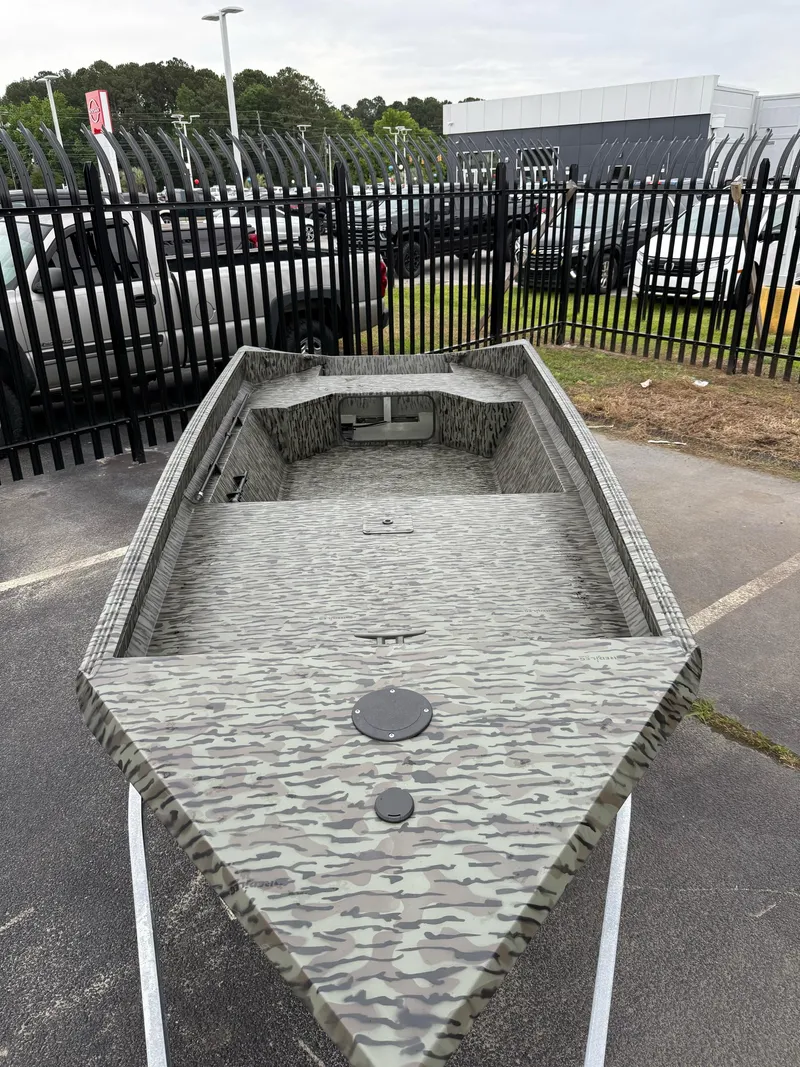 Slide: The Image of 2025 EDGE BOATS 553 Sportsman with camouflage design in a parking lot. - 3