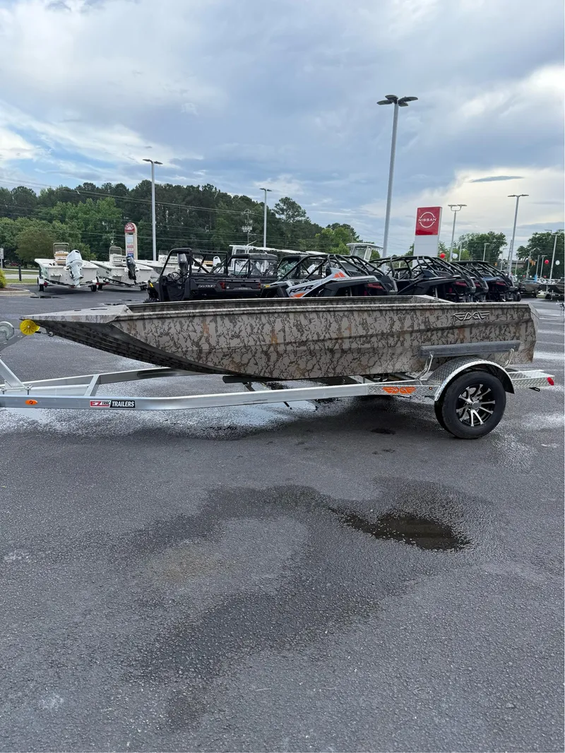 Slide: The Image of 2025 EDGE BOATS 656 SPORTSMAN on trailer in parking lot, cloudy sky background. - 2