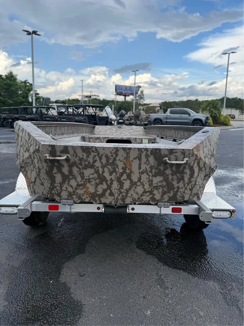 Slide: The Image of 2025 EDGE BOATS 656 SPORTSMAN on trailer, camo design, parked outdoors. - 4