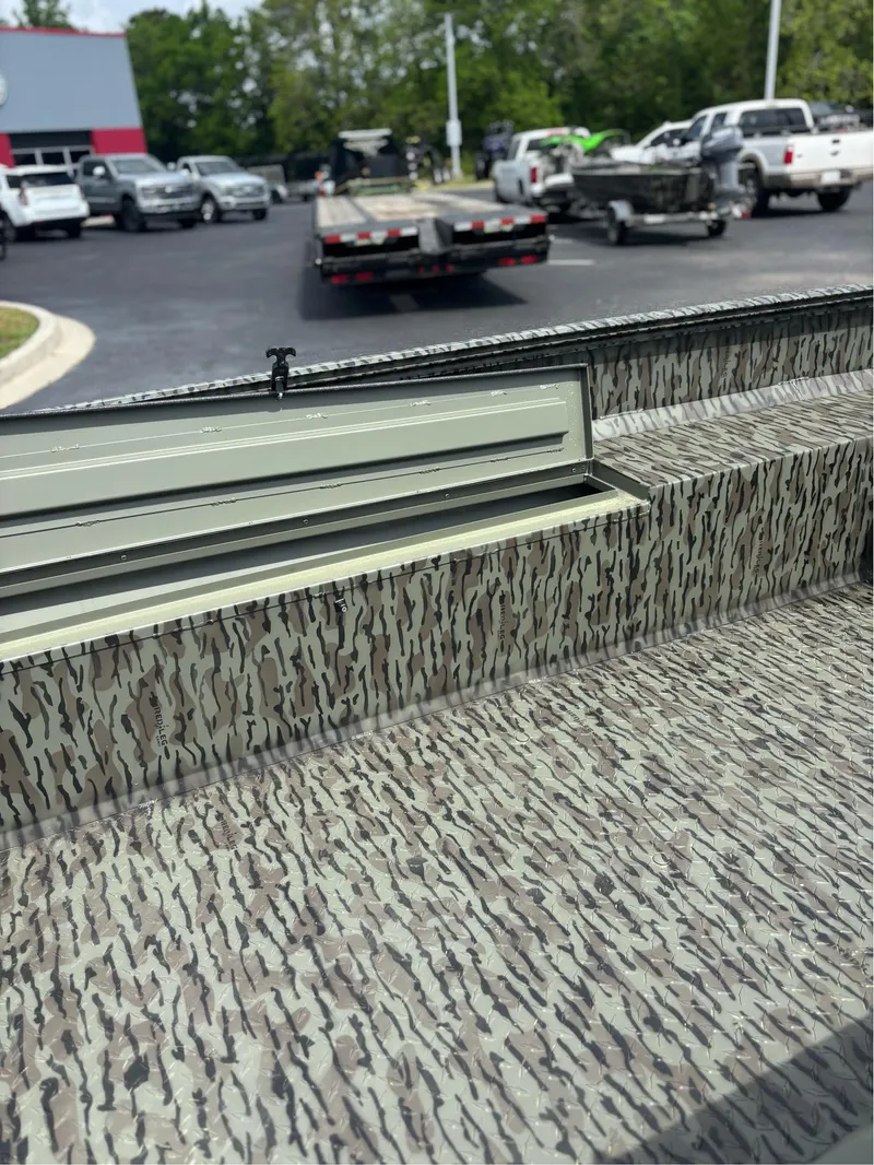 Slide: The Image of 2025 EDGE BOATS 753 with camouflage interior, parked in a lot with trailers. - 10