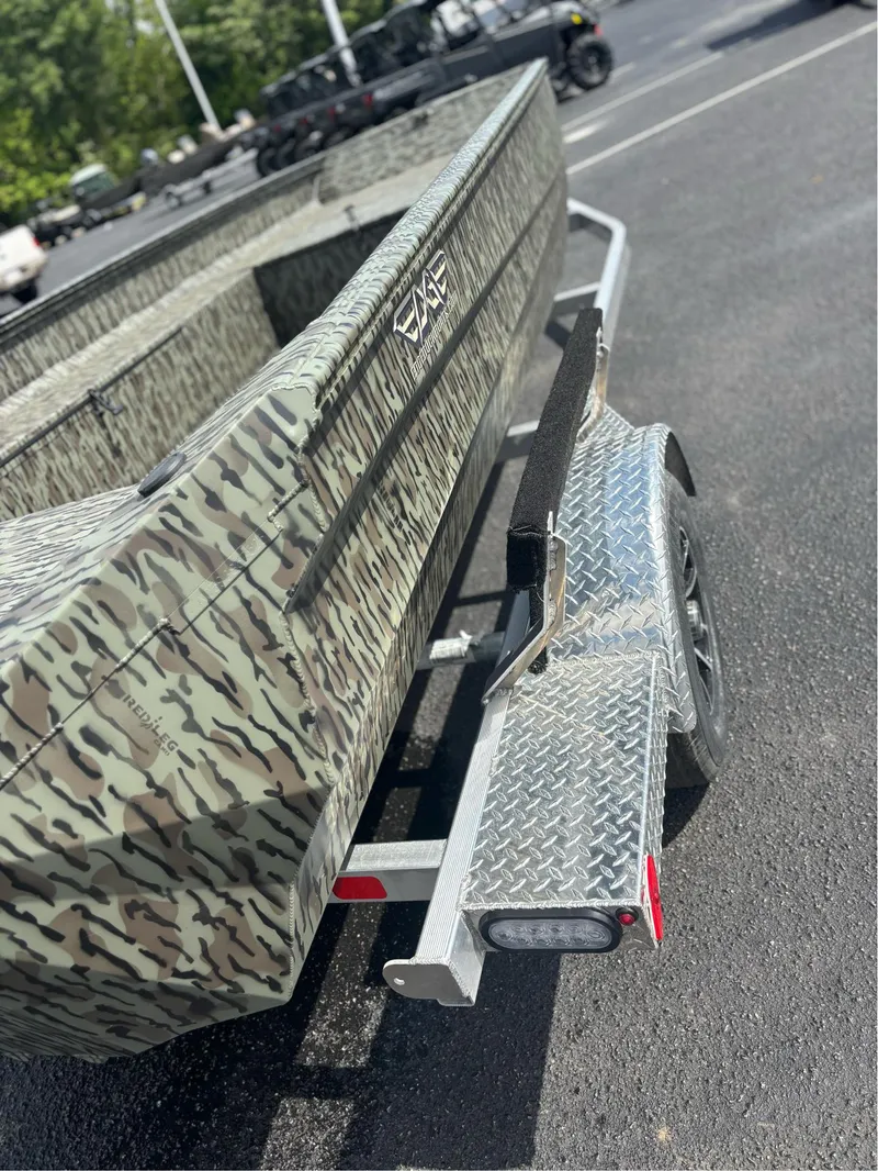 Slide: The Image of 2025 EDGE BOATS 753 camo-patterned boat on a trailer in a parking lot. - 14