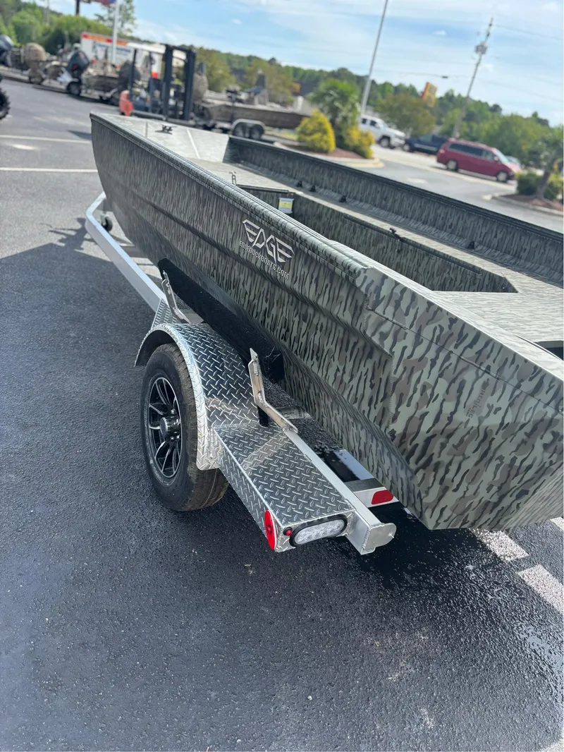 Slide: The Image of 2025 EDGE BOATS 753 on trailer, camo design, parked outdoors. - 15