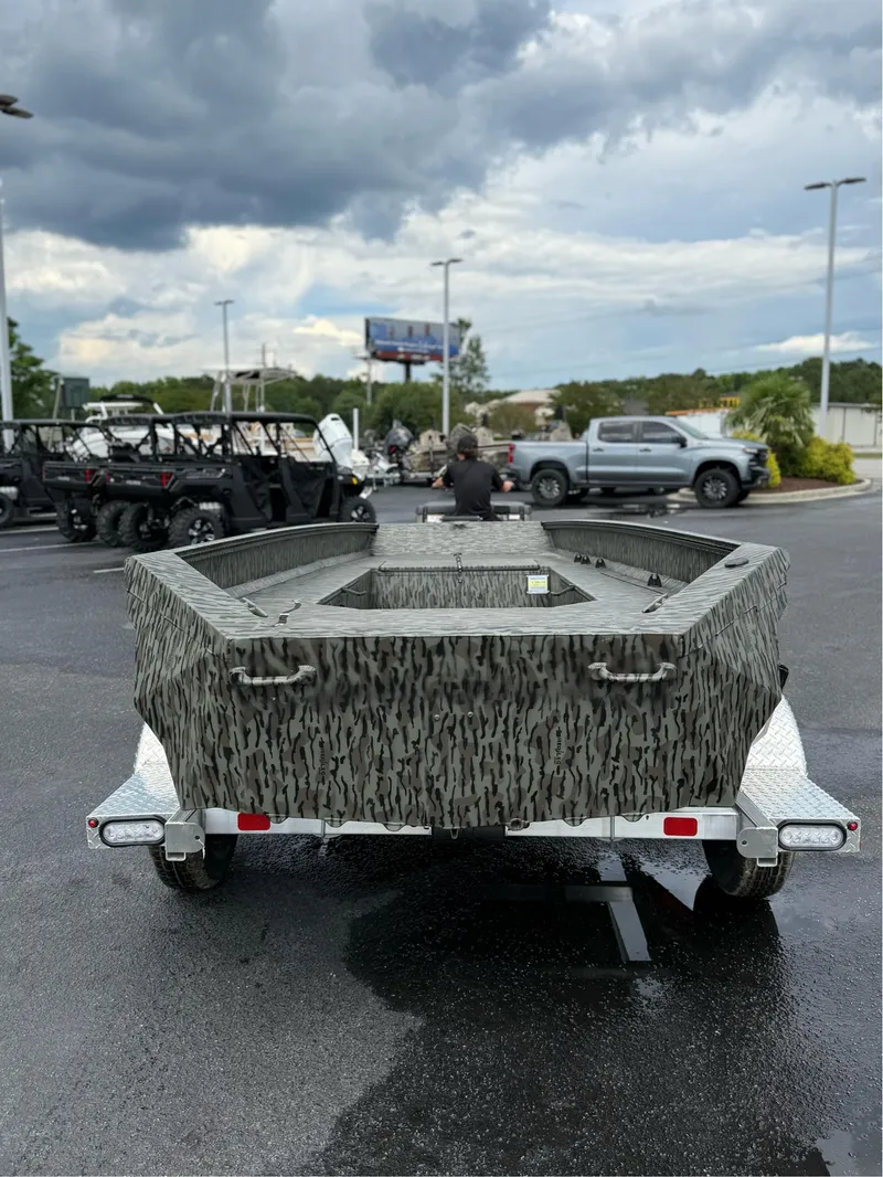 Slide: The Image of 2025 EDGE BOATS 753 on trailer, camo design, parked outdoors under cloudy sky. - 6