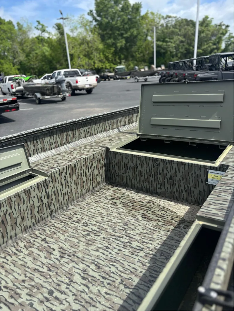 Slide: The Image of 2025 EDGE BOATS 753 with camouflage interior, open storage compartments, parked outdoors. - 8