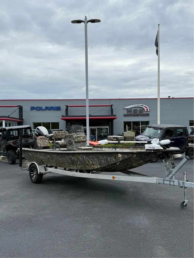Slide: The Image of 2022 War Eagle 961 Blackhawk boat on trailer at dealership, cloudy sky background. - 1