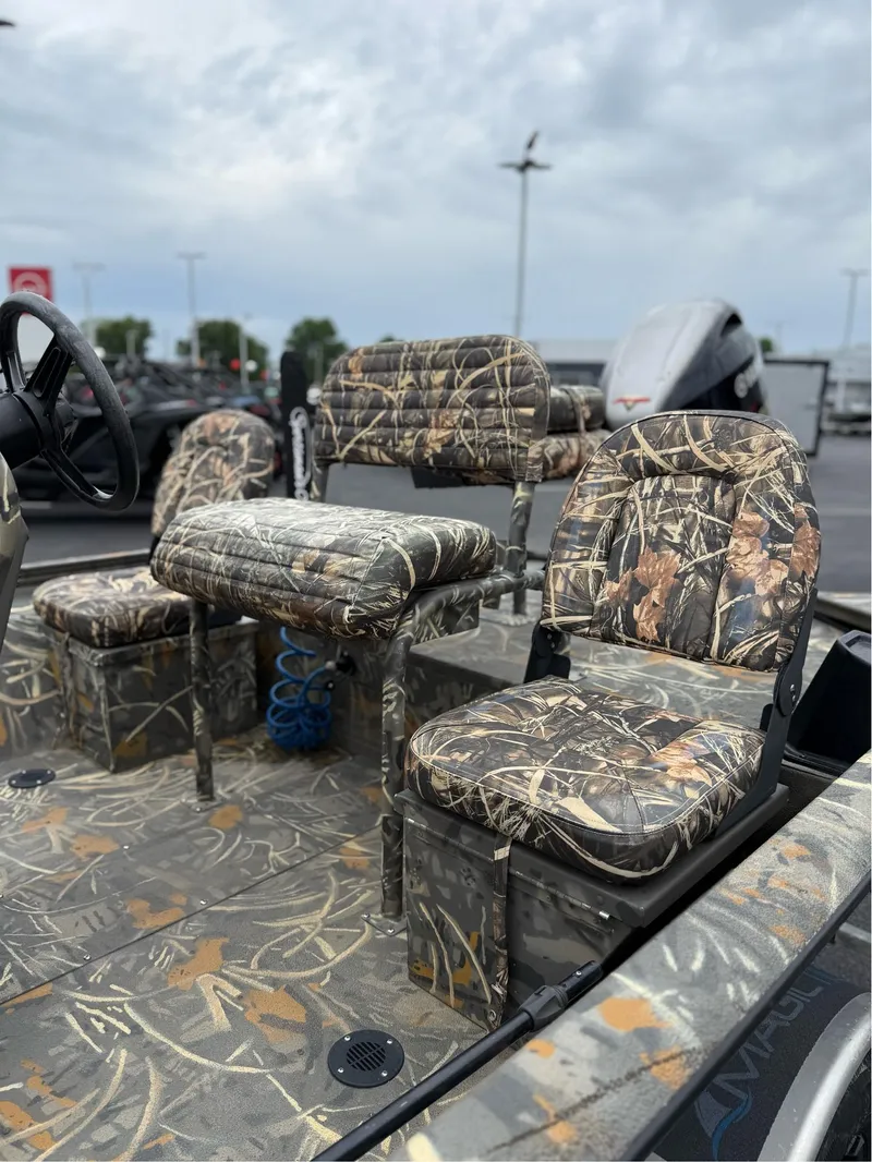 Slide: The Image of 2022 War Eagle 961 Blackhawk boat with camo seats and flooring, parked outdoors. - 11