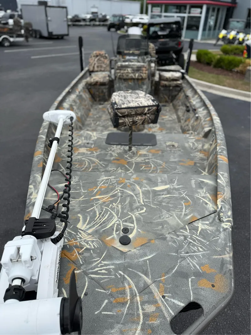 Slide: The Image of 2022 War Eagle 961 Blackhawk boat with camouflage design, parked outdoors. - 3