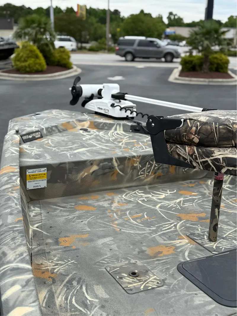 Slide: The Image of 2022 War Eagle 961 Blackhawk boat with camouflage design in a parking lot. - 8