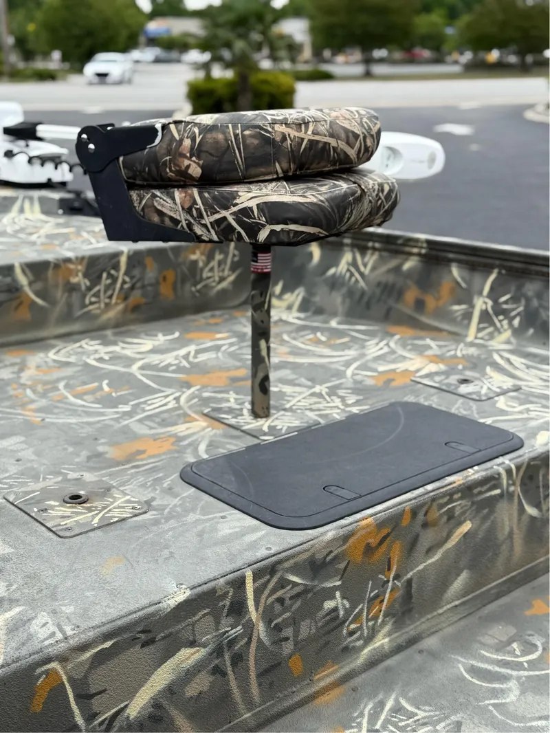 Slide: The Image of 2022 War Eagle 961 Blackhawk boat with camo seating and deck, parked outdoors. - 9