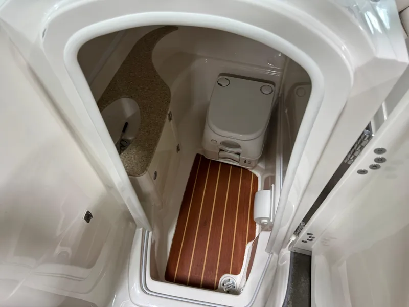 Slide: The Image of 2012 Monterey 264 FS boat bathroom with compact toilet and wooden floor mat. - 11