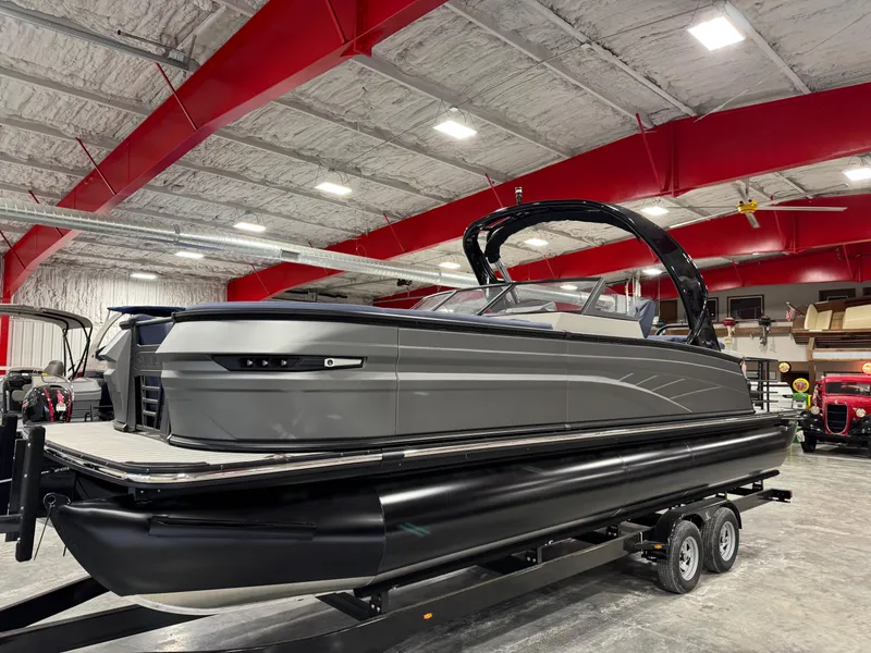 Slide: The Image of 2025 Sylvan G5 pontoon boat in showroom with red ceiling beams. - 1