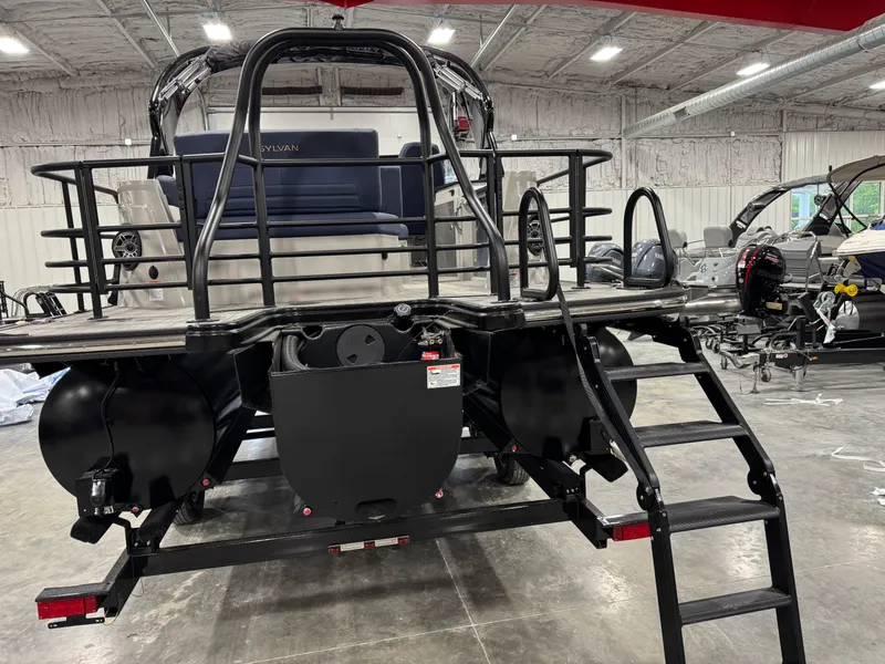 Slide: The Image of 2025 Sylvan G5 boat in a warehouse, rear view with ladder and seating. - 6