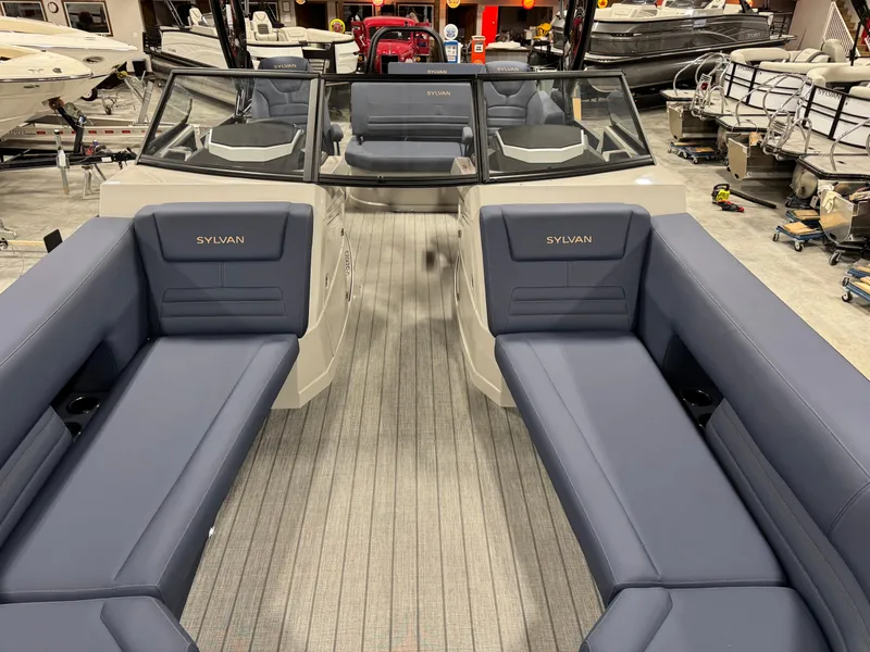 Slide: The Image of 2025 Sylvan G5 boat interior with blue seating and modern design in a showroom. - 8