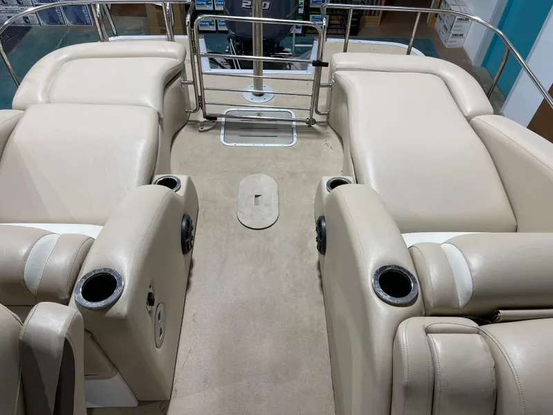 Slide: The Image of 2013 Bennington 22 R boat interior with beige seating and cup holders. - 24