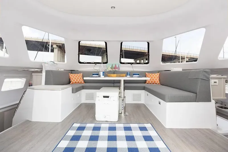 Slide: The Image of Interior of 2025 Seawind 1160 Lite catamaran with modern seating and dining area. - 10
