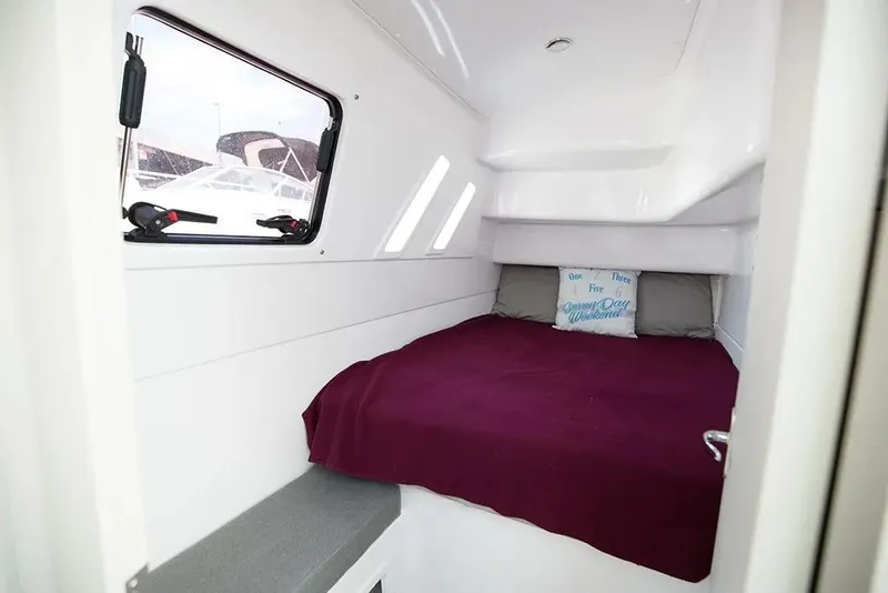 Slide: The Image of 2025 Seawind 1160 Lite cabin with cozy bed and window view. - 11