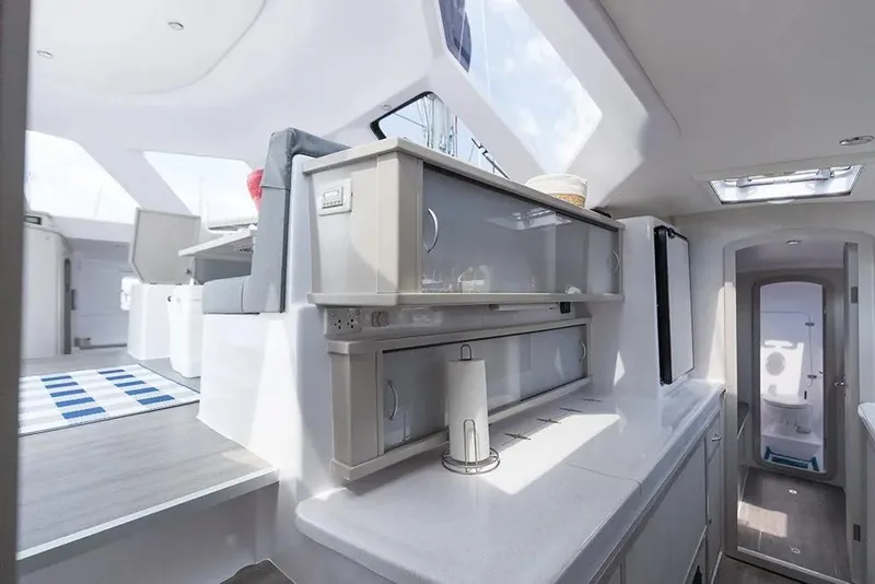 Slide: The Image of Interior of 2025 Seawind 1160 Lite catamaran, featuring modern kitchen and seating area. - 14