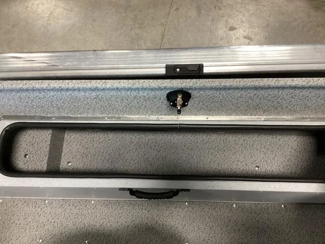 Slide: The Image of 2024 Lund 2075 Alaskan Sport boat interior storage compartment with handle and latch. - 11