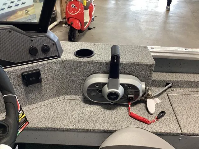 Slide: The Image of 2024 Lund 2075 Alaskan Sport boat control panel with throttle and cup holder. - 12