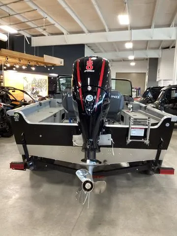 Slide: The Image of 2024 Lund 2075 Alaskan Sport boat displayed indoors, rear view with motor. - 4