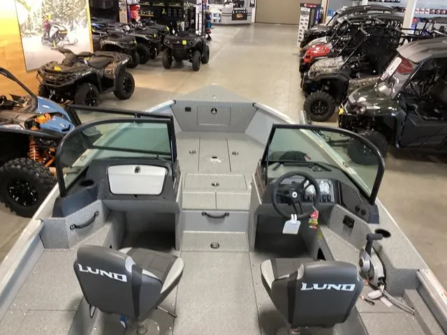Slide: The Image of 2024 Lund 2075 Alaskan Sport boat interior in showroom with ATVs in background. - 5