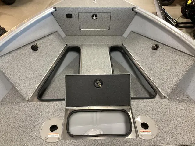 Slide: The Image of 2024 Lund 2075 Alaskan Sport boat interior with storage compartments and gray textured flooring. - 7