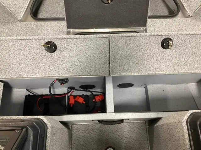 Slide: The Image of 2024 Lund 2075 Alaskan Sport boat interior storage compartments with battery and wiring. - 8