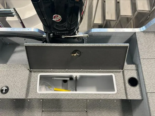 Slide: The Image of 2024 Lund 1875 Alaskan DC boat interior with storage compartment and motor. - 13