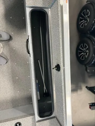 Slide: The Image of 2024 Lund 1875 Alaskan DC boat interior storage compartment with visible handle and lock. - 19