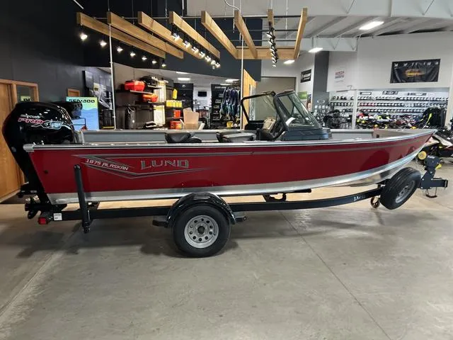 Slide: The Image of 2024 Lund 1875 Alaskan DC boat in showroom, red exterior, on trailer. - 5