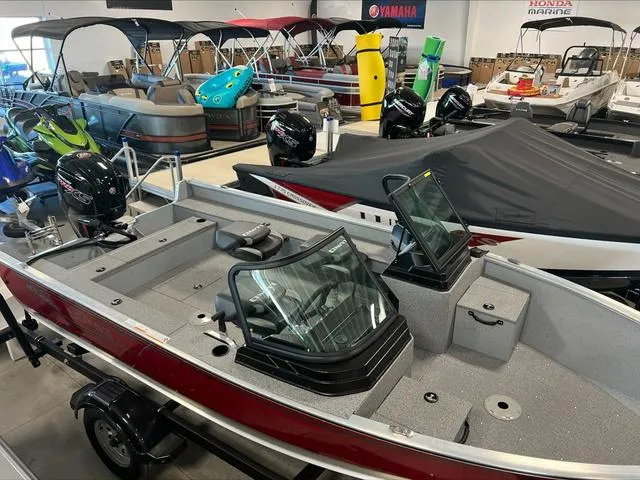 Slide: The Image of 2024 Lund 1875 Alaskan DC boat in showroom, surrounded by various marine equipment. - 8
