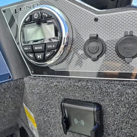 Slide: The Image of 2025 Lund 1775 Adventure Sport dashboard with audio controls and 12V outlets. - 11