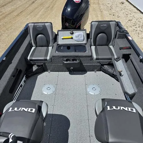 Slide: The Image of 2025 Lund 1775 Adventure Sport boat interior with seating and motor, on a sandy surface. - 12