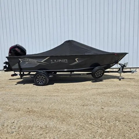 Slide: The Image of 2025 Lund 1775 Adventure Sport boat with cover on trailer, parked outdoors. - 5