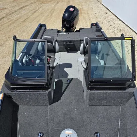 Slide: The Image of 2025 Lund 1775 Adventure Sport boat with dual consoles and outboard motor, parked on sandy ground. - 6