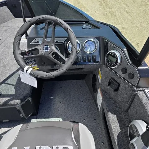 Slide: The Image of 2025 Lund 1775 Adventure Sport boat dashboard with steering wheel and gauges. - 9