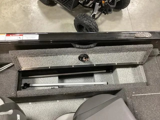 Slide: The Image of 2024 Lund 1650 Rebel XL SS boat interior storage compartment with gray seating. - 7