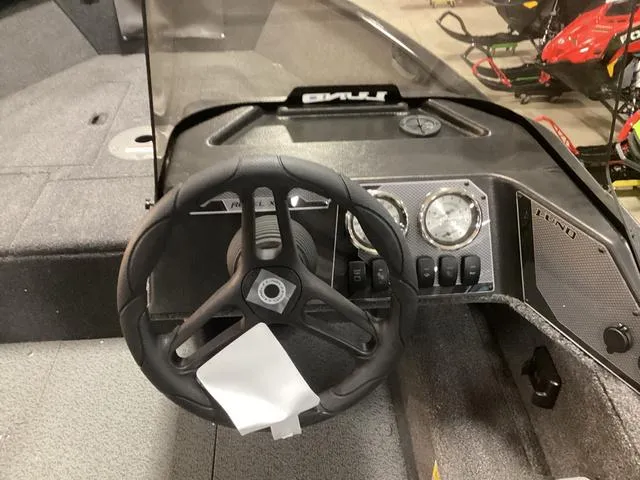 Slide: The Image of 2024 Lund 1650 Rebel XL SS boat dashboard with steering wheel and gauges. - 9
