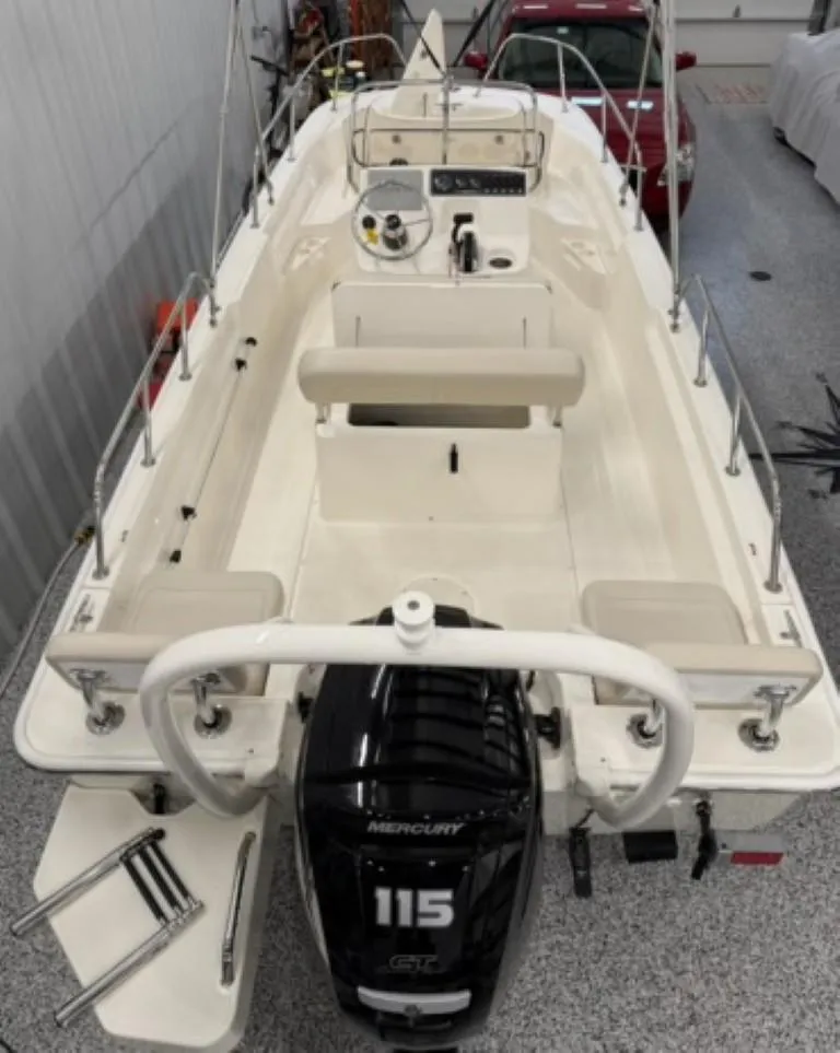 Slide: The Image of 2021 Boston Whaler 170 Montauk boat with Mercury 115 engine in a garage. - 10
