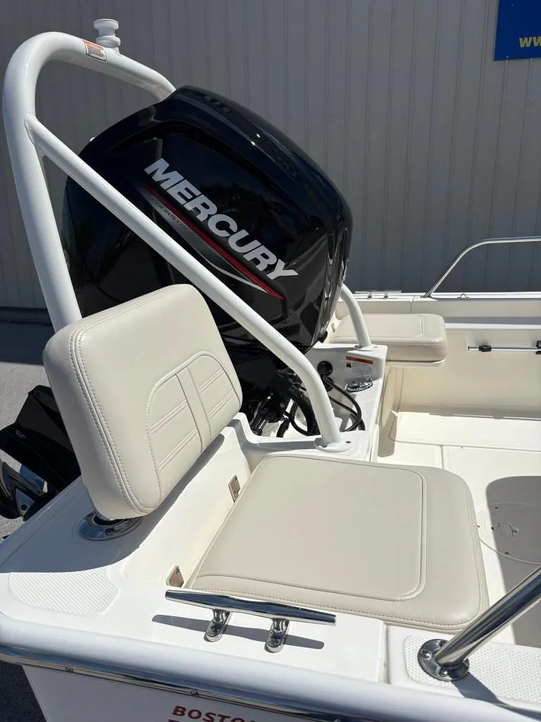 Slide: The Image of 2021 Boston Whaler 170 Montauk with Mercury engine, featuring white seating and railings. - 2