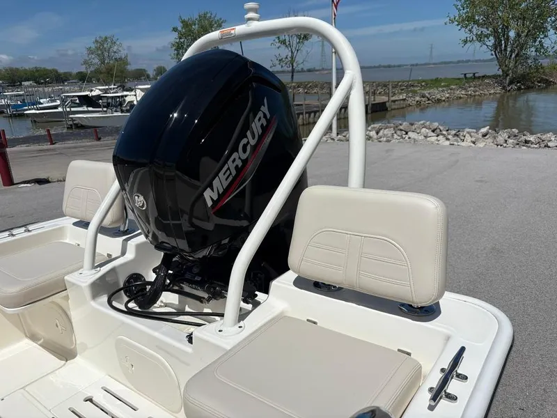 Slide: The Image of 2021 Boston Whaler 170 Montauk with Mercury engine, docked near a scenic waterfront. - 5