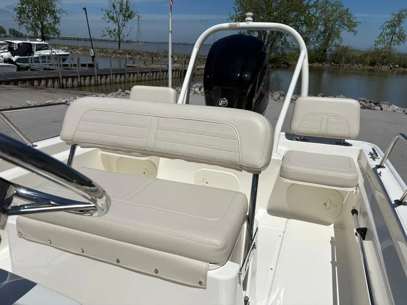 Slide: The Image of 2021 Boston Whaler 170 Montauk boat interior with beige seating and outboard motor. - 7
