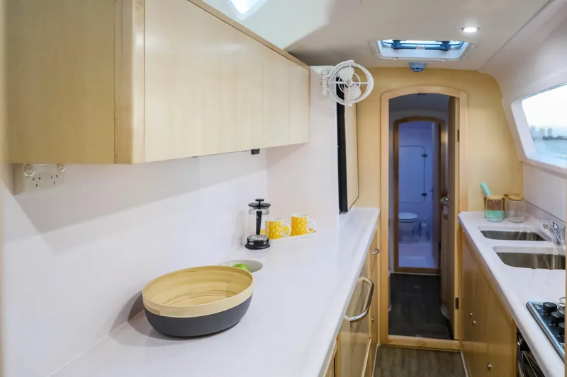 Slide: The Image of Modern kitchen interior of 2025 Seawind 1260 catamaran with sleek countertops and wooden cabinetry. - 23